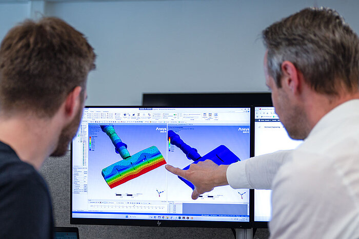 社員と顧客が食品切断用部品の図を分析している
