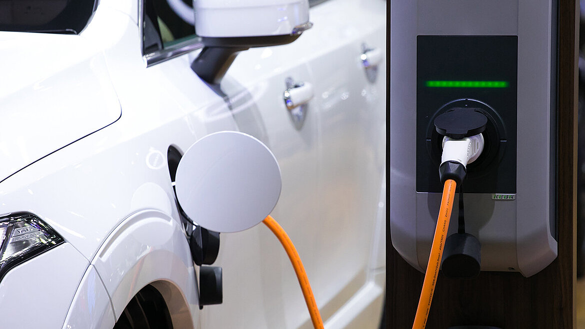 ケーブルで充電ステーションに接続された電気自動車