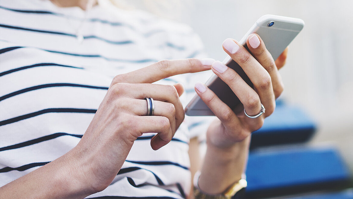 スマートフォンを手に持った人物